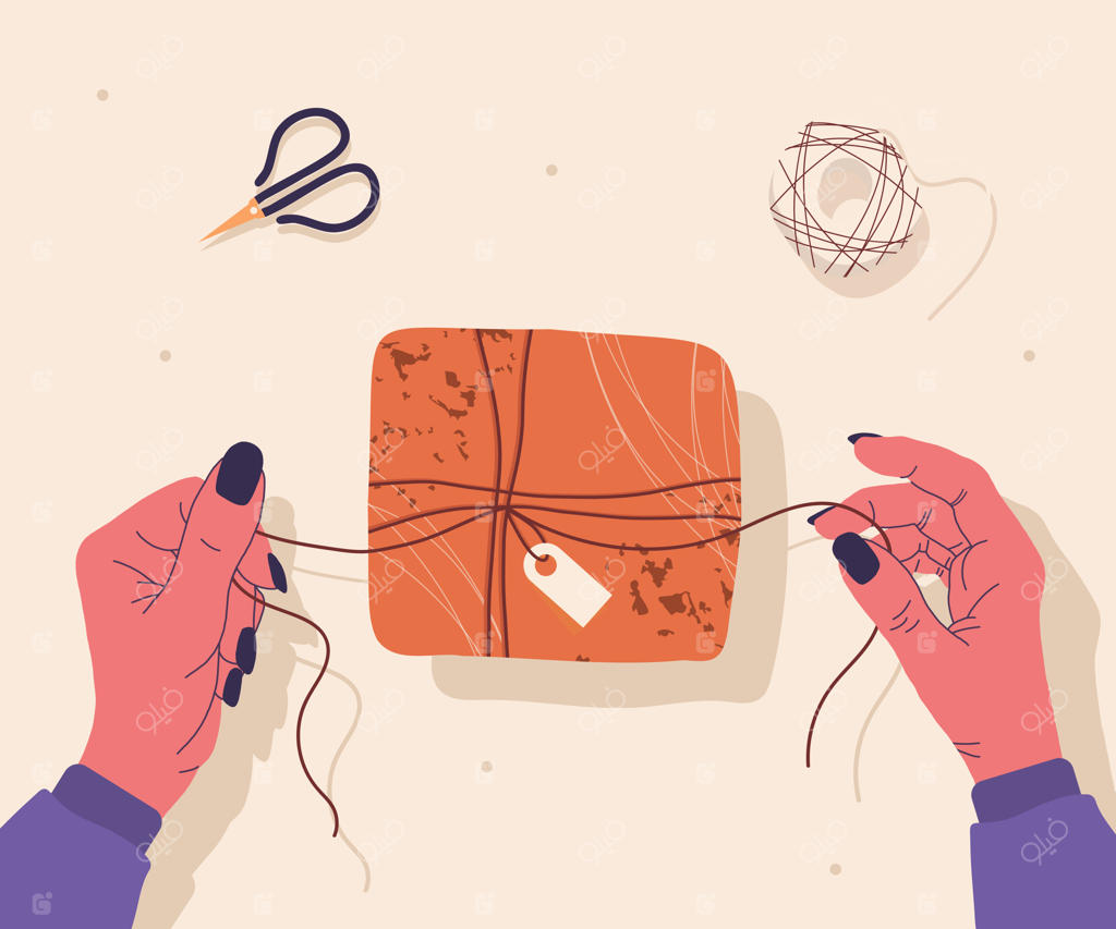 دست‌ها و جعبه کادو روی میز: تصویر مدرن و دست‌کشی از دست‌ها، جعبه کادو، قیچی و شاخه درخت از نمای بالا.